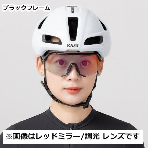 カスクのヘルメットを着用し、ALTALISTの調光レンズ（レッドミラー）を装備したサングラスをかけた女性ライダーが、スポーティでスタイリッシュな姿勢を見せているシーンを捉えています。