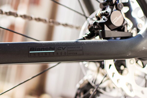 BianchiのCV（Countervail）振動減衰技術を採用したフレームを示しています。振動吸収性を向上させ、快適性とパフォーマンスを両立。背景にはディスクブレーキが見えます。