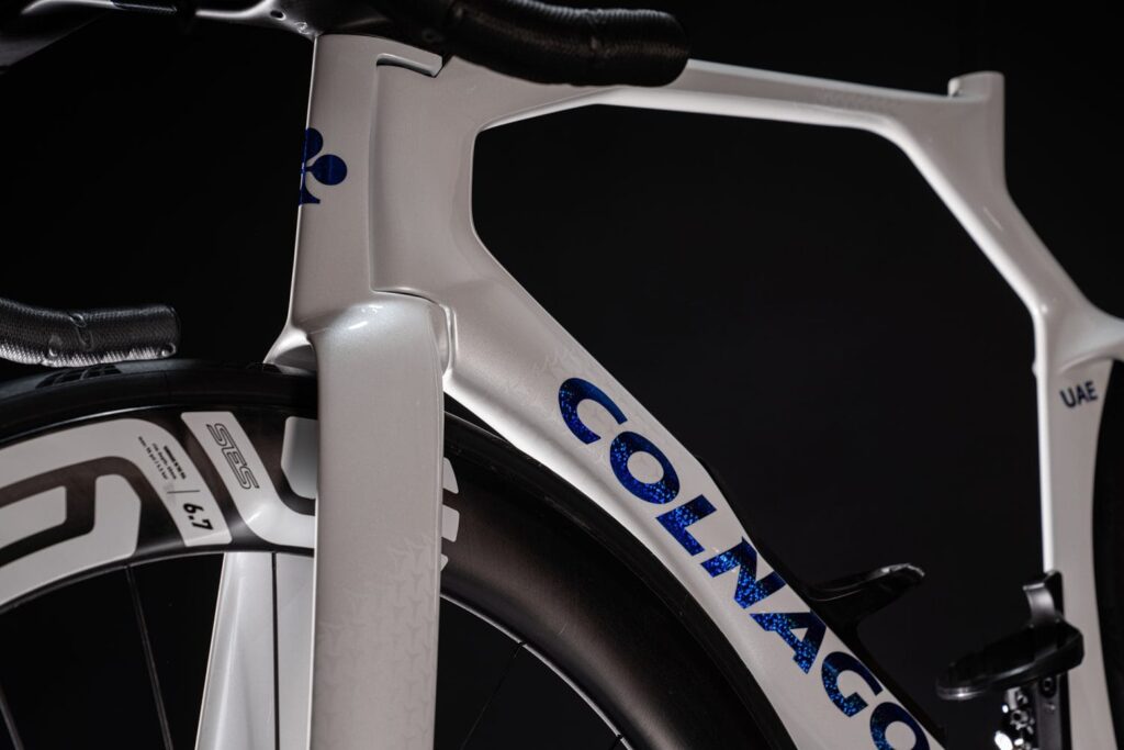 Colnago Y1RSのフレームをクローズアップした画像。特徴的なエアロ形状のフロントフォークと流線型のトップチューブが際立ち、空力性能を最大限に追求した設計が強調されている。ホイールにはENVE SES 6.7が装着され、スピード性能を重視した仕様。UAEチームエディションを示すマーキングも確認できる。