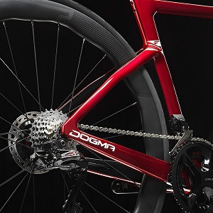 この画像は、Pinarello DOGMA Fのリアセクションをクローズアップしたもの。エアロ形状のチェーンステーと高精度なリアディレイラーが特徴で、軽量かつ高剛性なフレームがスムーズなパワー伝達を実現する。